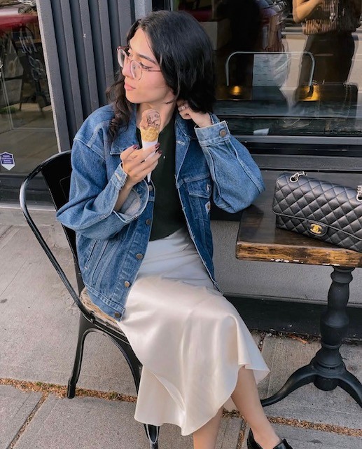 woman sitting in cafe wearing denim jacket