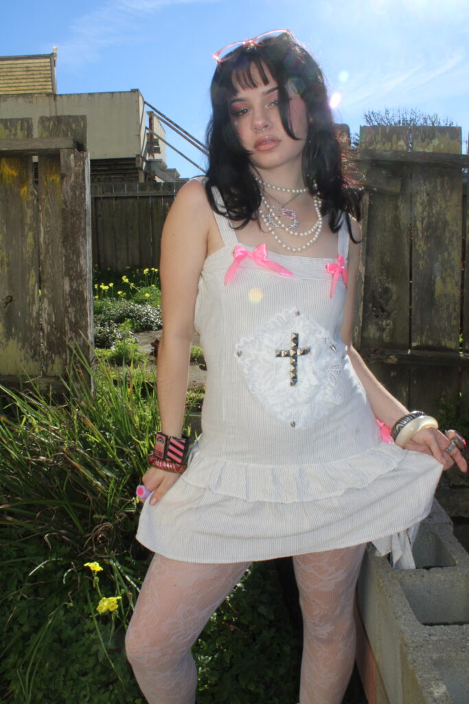 Pride 2026 Model wearing white dress with pink bow and gold stud details