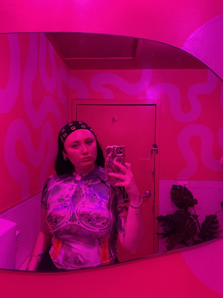 Aili taking a selfie in a pink room