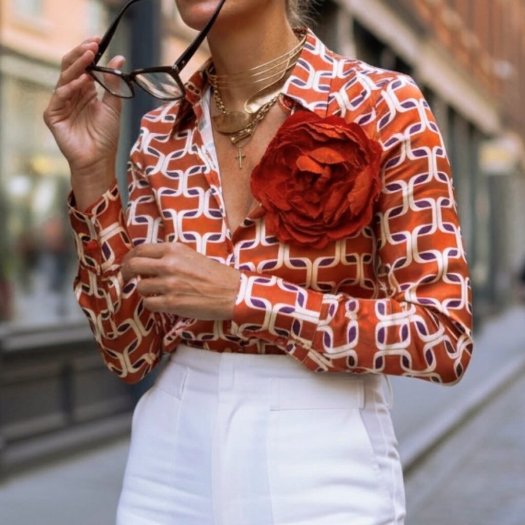woman wearing a button down with flower pin