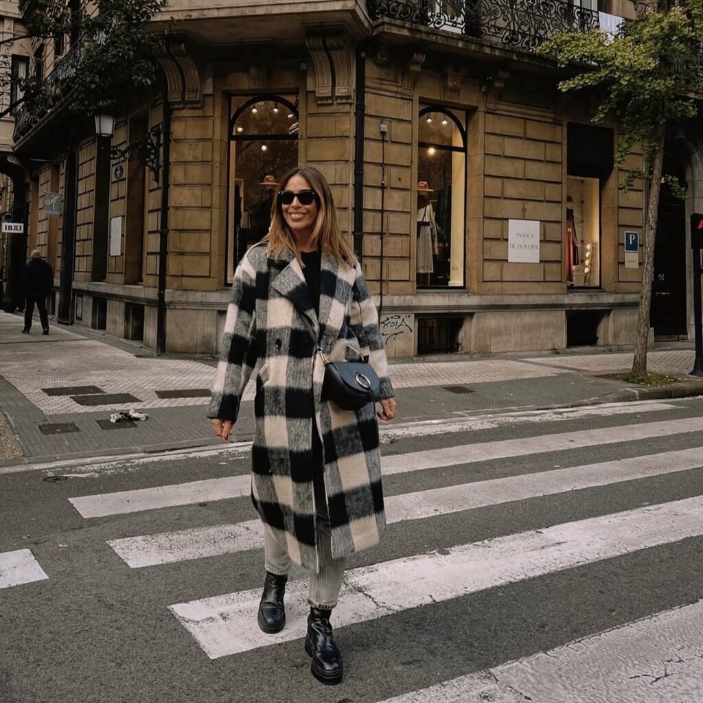 woman in plaid coat with gray pants and black combat boots