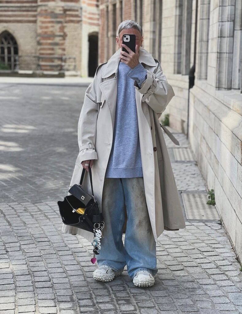 woman in oversized sweatshirt, jeans, and trench coat