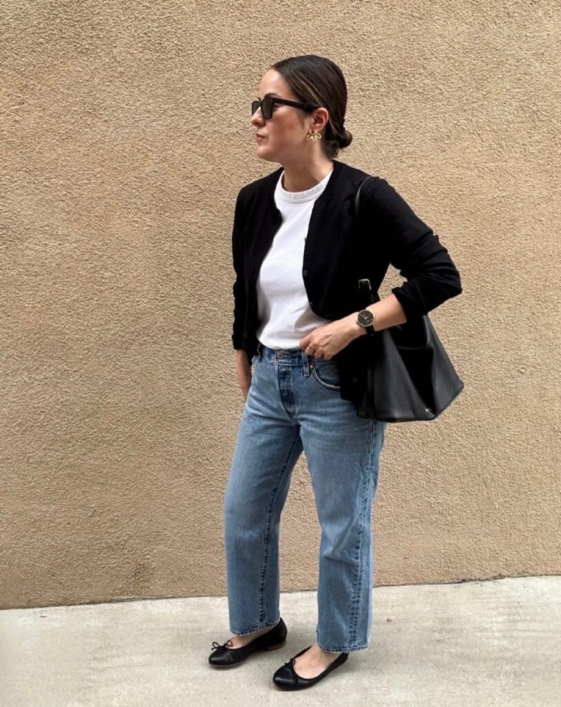 woman in jeans, white tee, and black cardigan