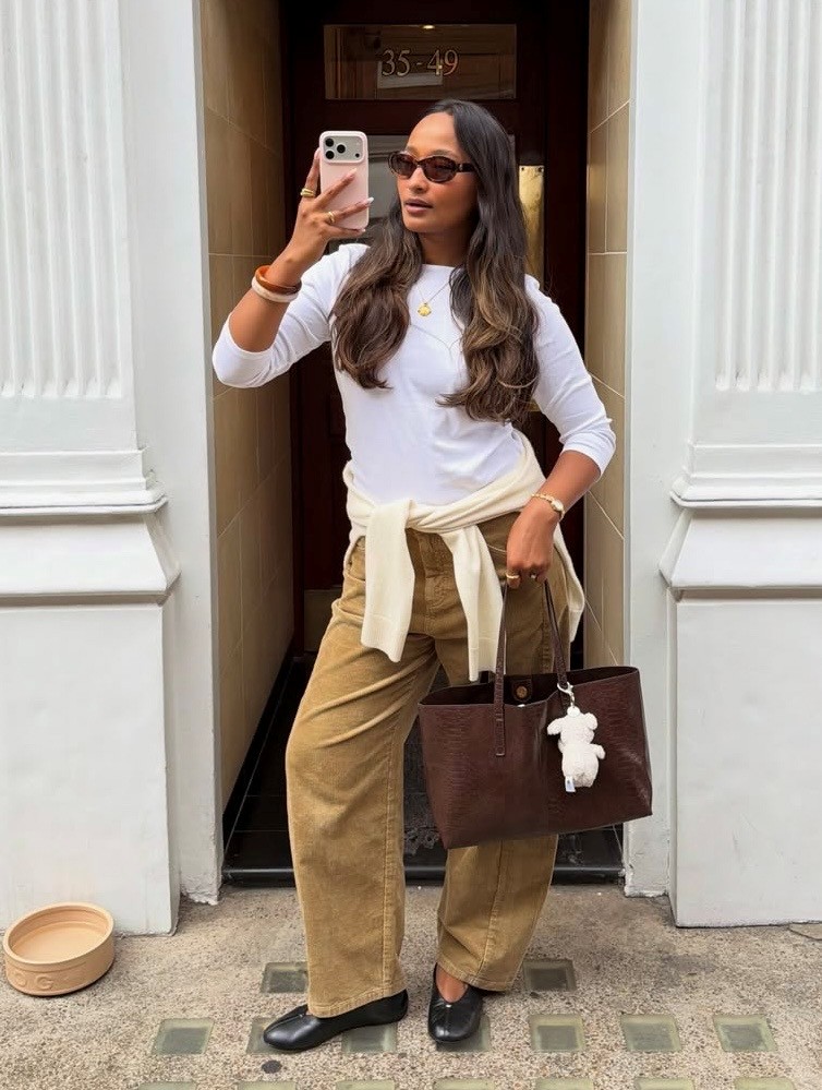 woman in tan corduroy pants and white long-sleeve tee