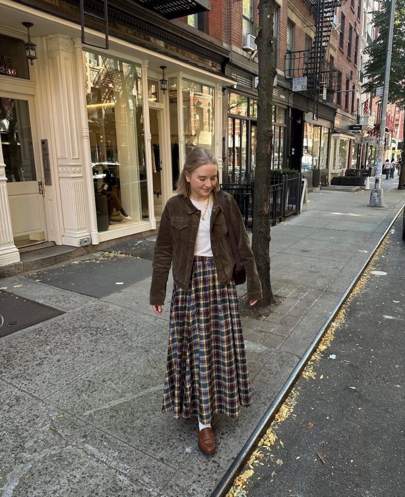 woman in long paid skirt, tee, and corduroy jacket