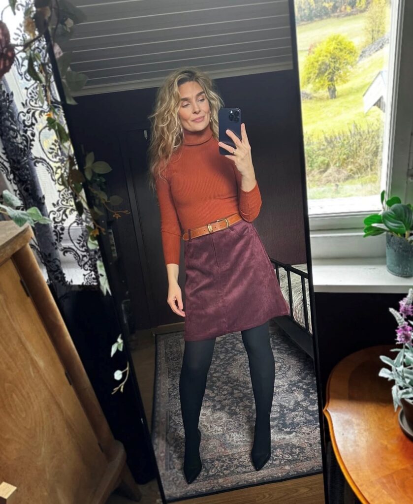 woman in burnt orange turtleneck with corduroy skirt and tights